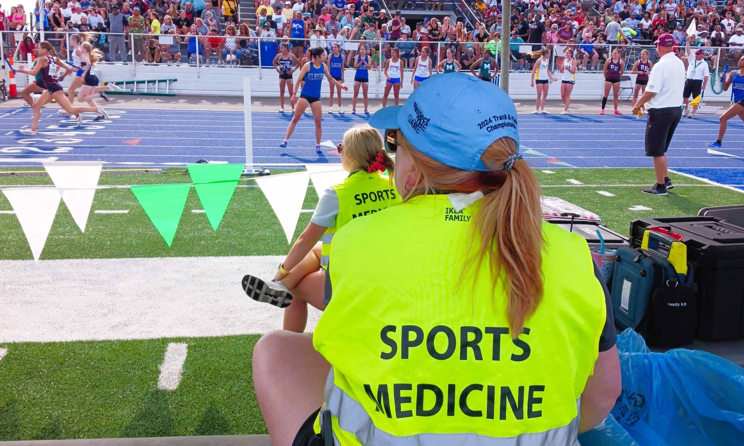 Sports medicine provider sitting on sidelines