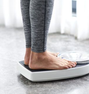Woman standing on scale, showing just her feet