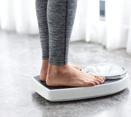 Woman standing on scale, showing just her feet