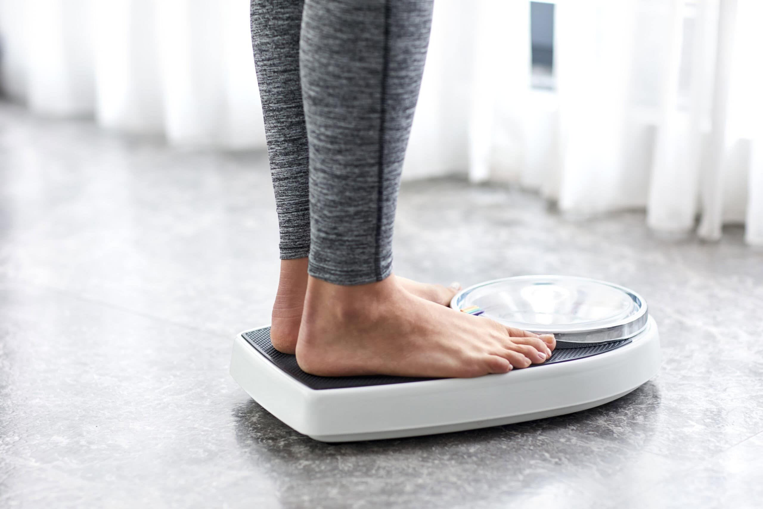 Woman standing on scale, showing just her feet