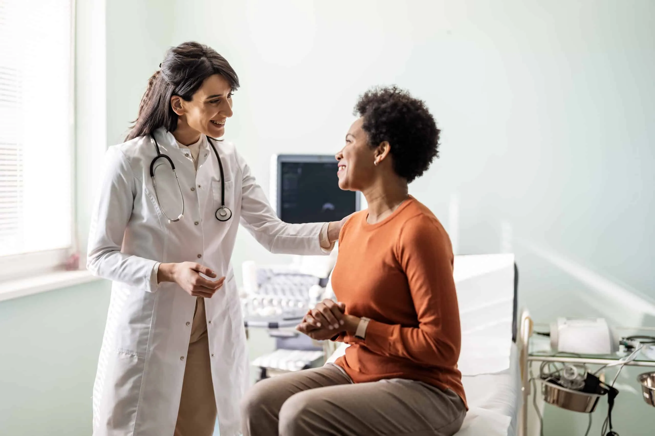 Female primary care provider reassuring a patient