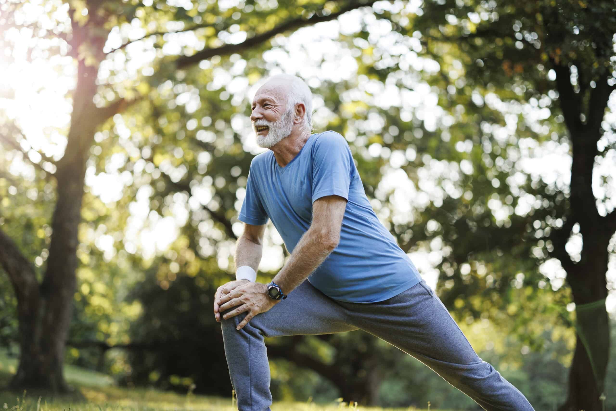 Shot of a senior man standing alone and stretching during his outdoor workout