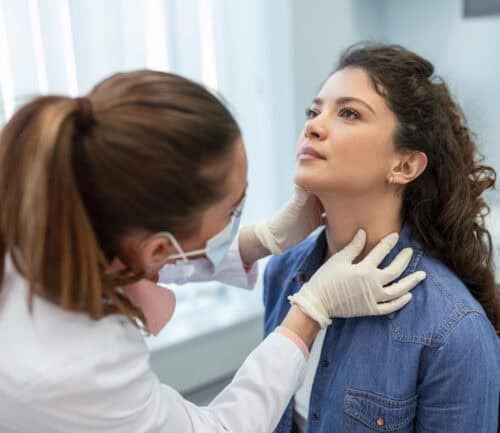 Woman getting her thyroid checked by a doctor