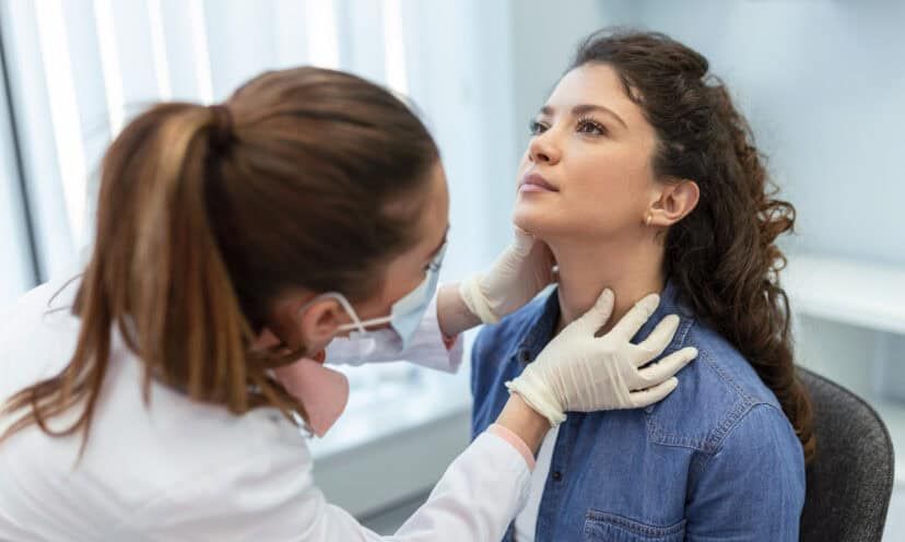 Woman getting her thyroid checked by a doctor