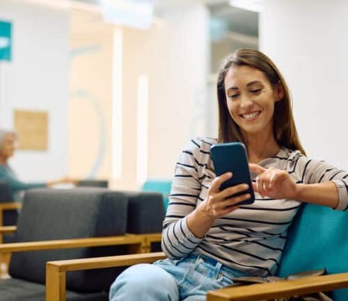 Woman using her phone in waiting room