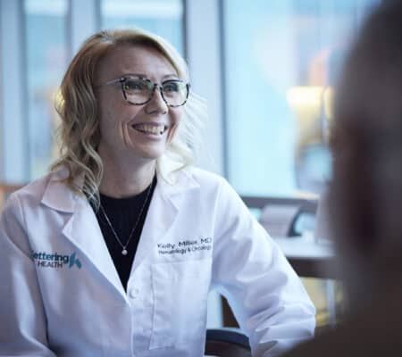 Female doctor talking to a patient, smiling.
