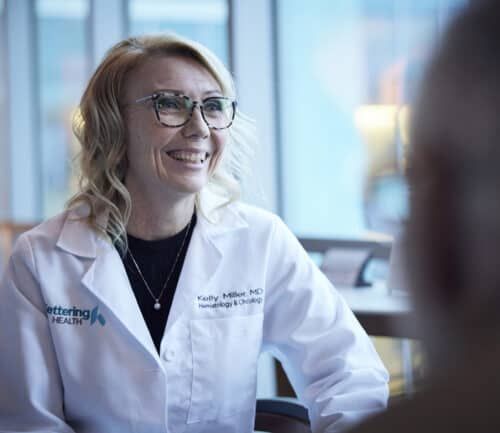 Female doctor talking to a patient, smiling.