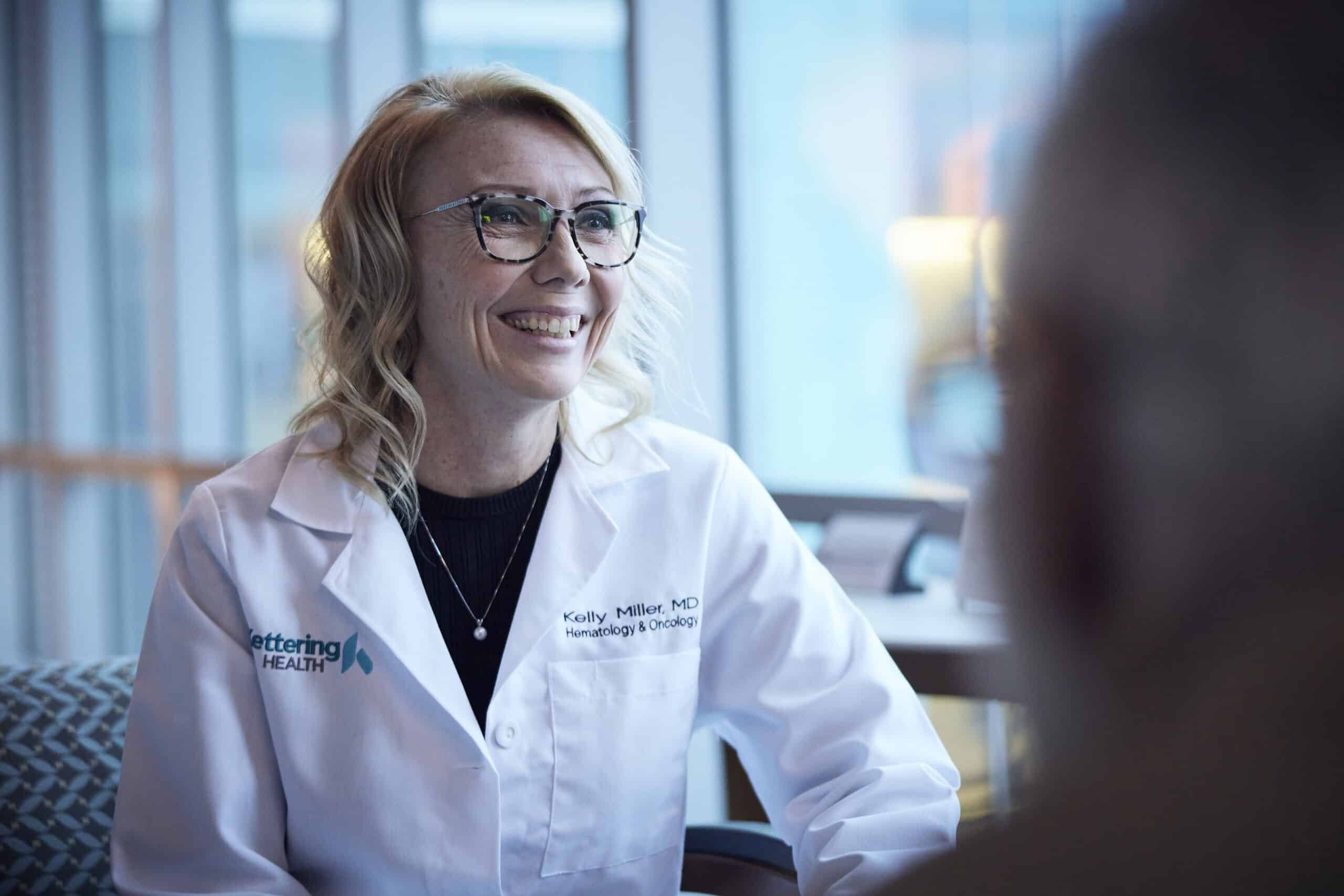 Female doctor talking to a patient, smiling.