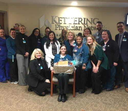 Healthcare team celebrating with gift basket presentation at Kettering Physician Network office