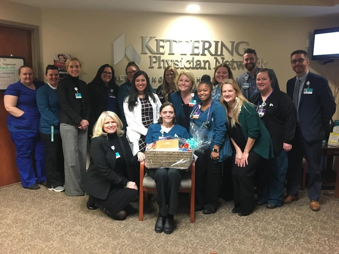 Healthcare team celebrating with gift basket presentation at Kettering Physician Network office