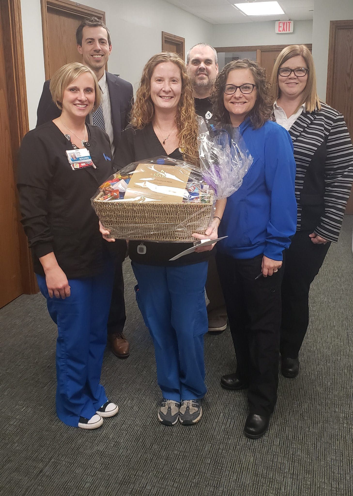 Healthcare team presenting gift basket to employee recognition award recipient