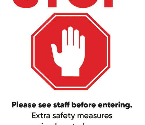 Red stop sign with hand symbol and safety message for healthcare facility entrance