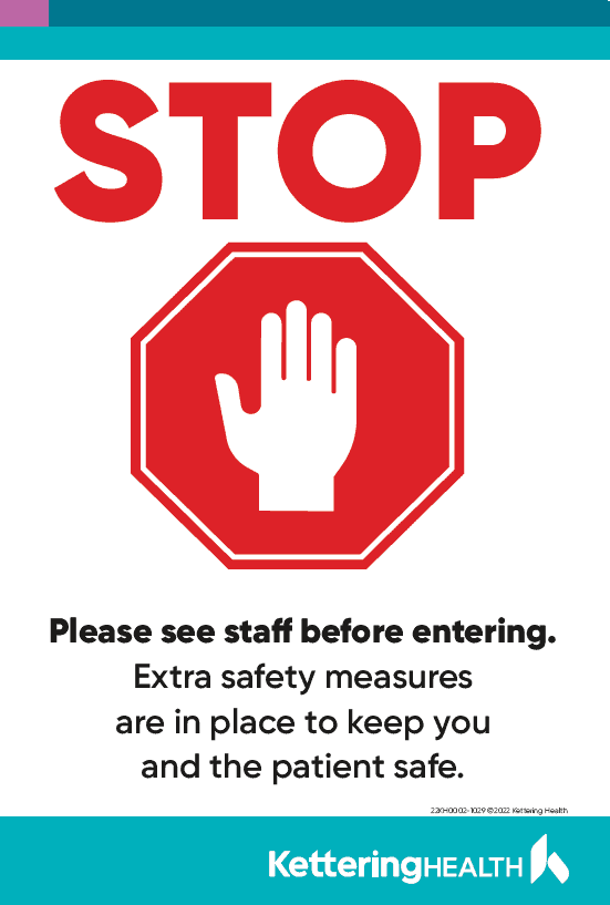 Red stop sign with hand symbol and safety message for healthcare facility entrance