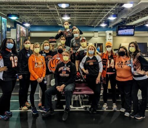 Healthcare workers wearing Cincinnati Bengals gear and face masks gathered in medical facility