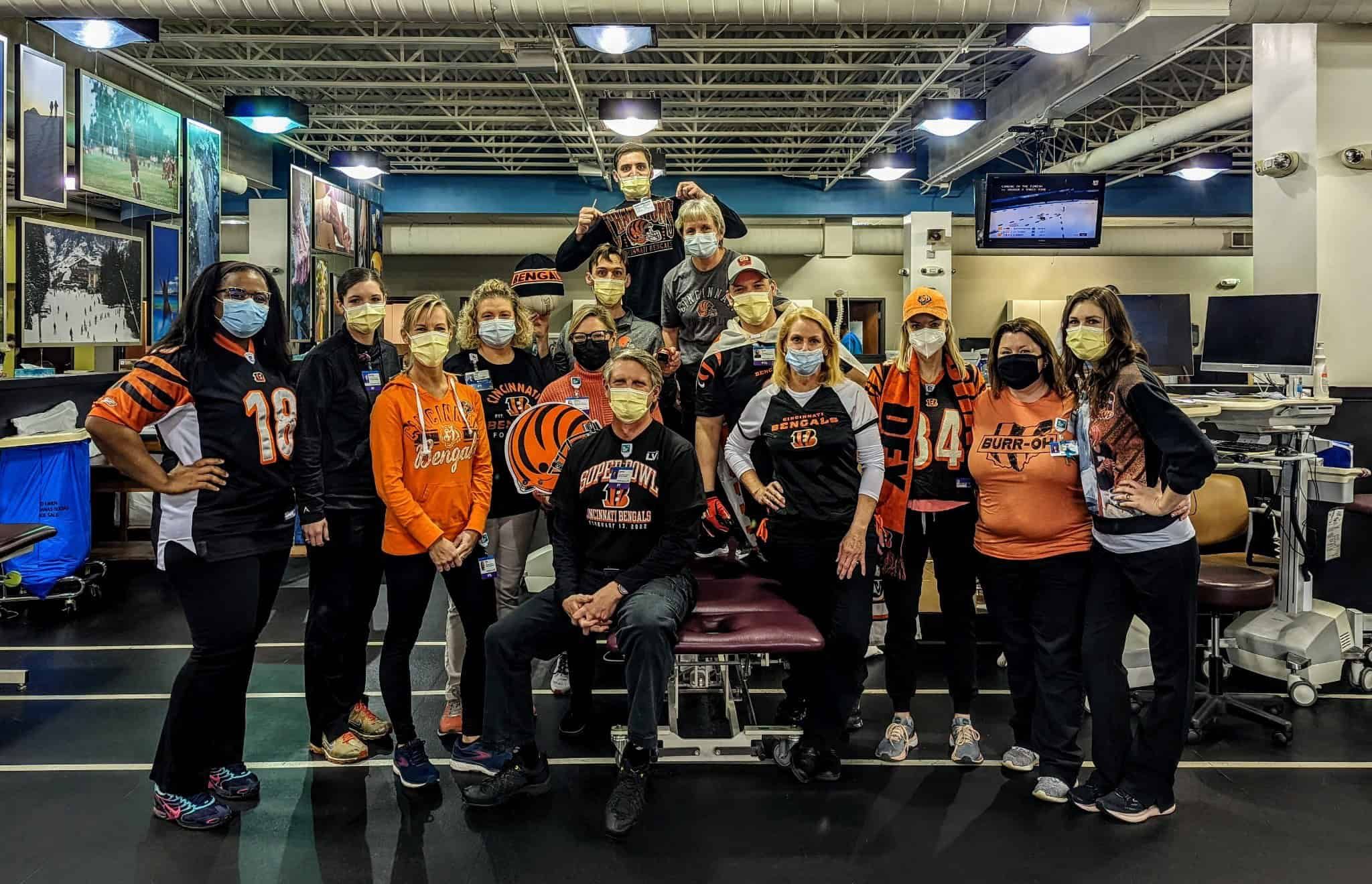 Healthcare workers wearing Cincinnati Bengals gear and face masks gathered in medical facility
