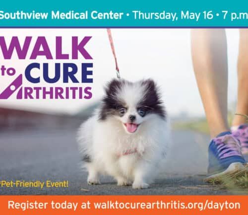 Small fluffy dog on leash with person's legs, promoting Walk to Cure Arthritis event