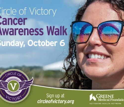 Woman with sunglasses smiling outdoors promoting Circle of Victory Cancer Awareness Walk October 6