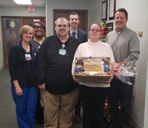 Healthcare staff presenting gift basket to employee of the month winner