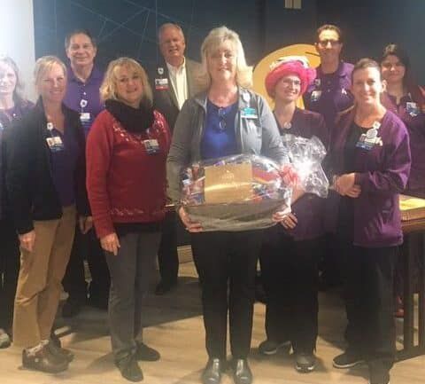 Healthcare staff celebrating employee recognition with gift basket presentation ceremony