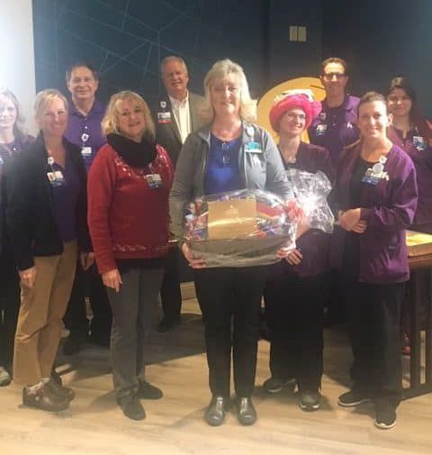 Healthcare staff celebrating employee recognition with gift basket presentation ceremony