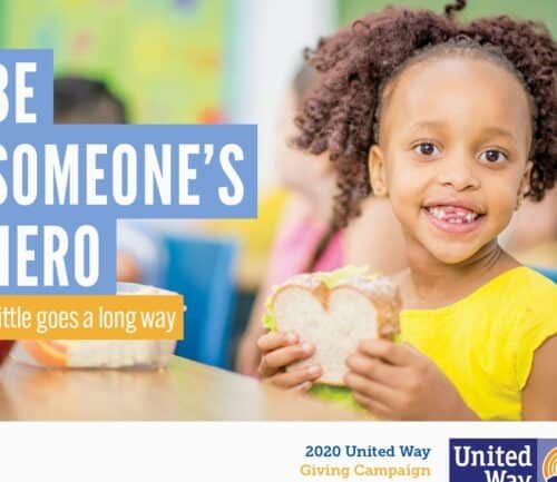 Young girl holding sandwich with United Way campaign message "Be Someone's Hero"