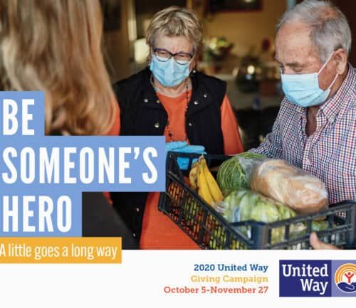 Two masked volunteers delivering groceries to woman during United Way campaign