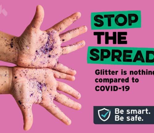 Hands covered in glitter with "Stop the Spread" COVID-19 safety message