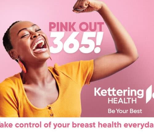 Woman flexing bicep in yellow top promoting Kettering Health breast cancer awareness campaign