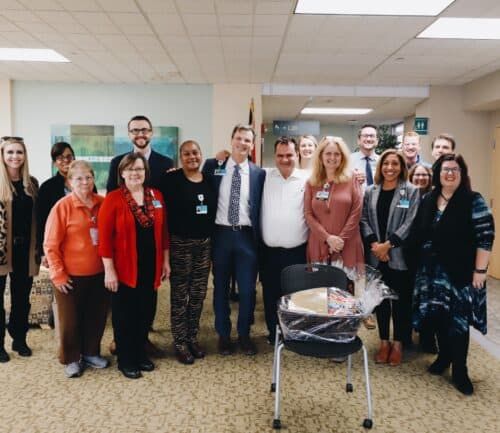 Group of Kettering Health employees posing together in hospital lobby area