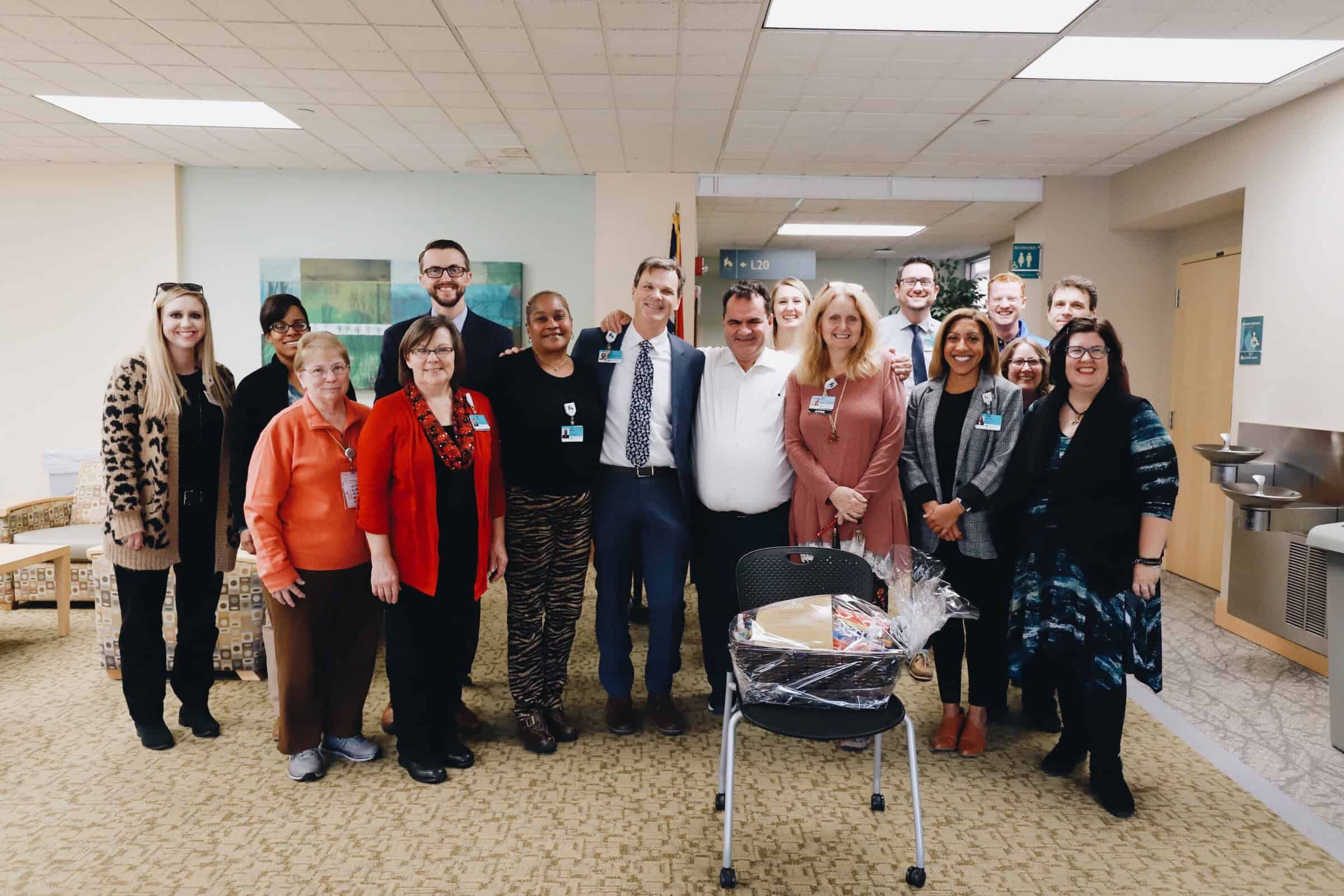 Group of Kettering Health employees posing together in hospital lobby area