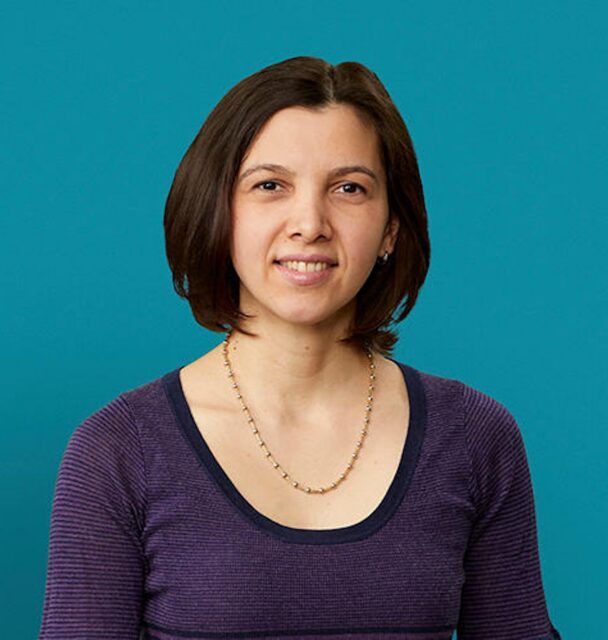 Professional headshot of Dr. Emanuela Cimpeanu smiling against teal background