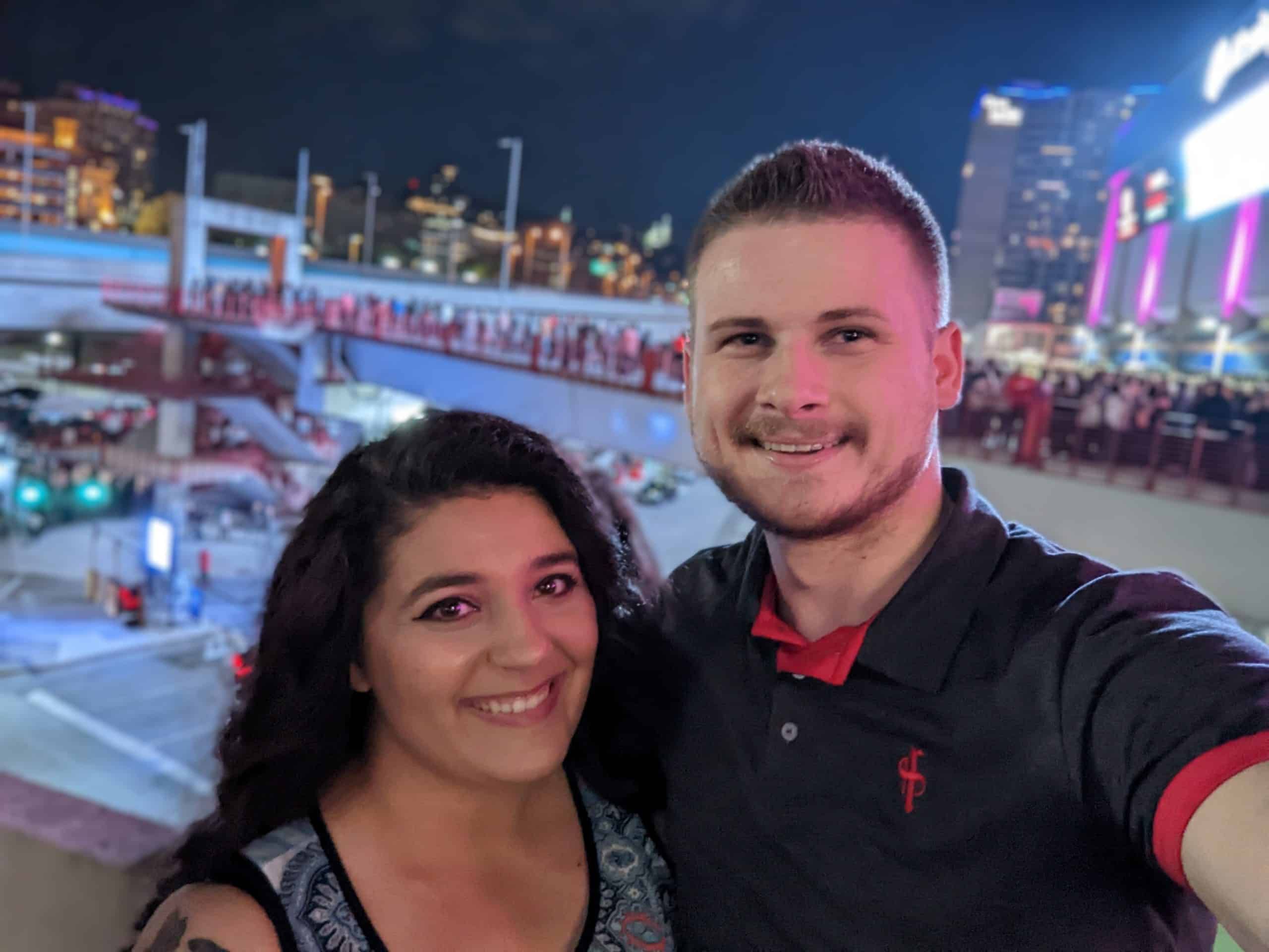 Young couple taking selfie together at nighttime outdoor ice skating rink