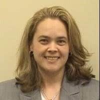 Professional headshot of Beth, healthcare provider smiling in gray blazer