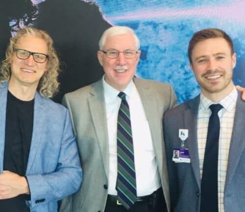 Three healthcare professionals in business attire posing together at Brain-Spine open house event.