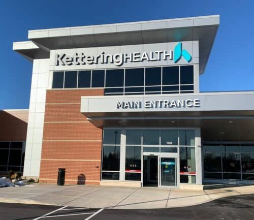 Modern Kettering Health medical facility with glass entrance and brick exterior details.