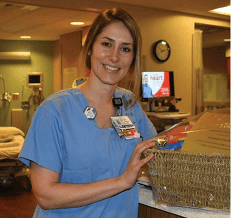 Healthcare worker in blue scrubs holding clipboard in hospital setting