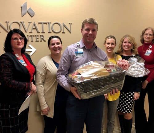 Group of healthcare employees presenting gift basket at Innovation Center