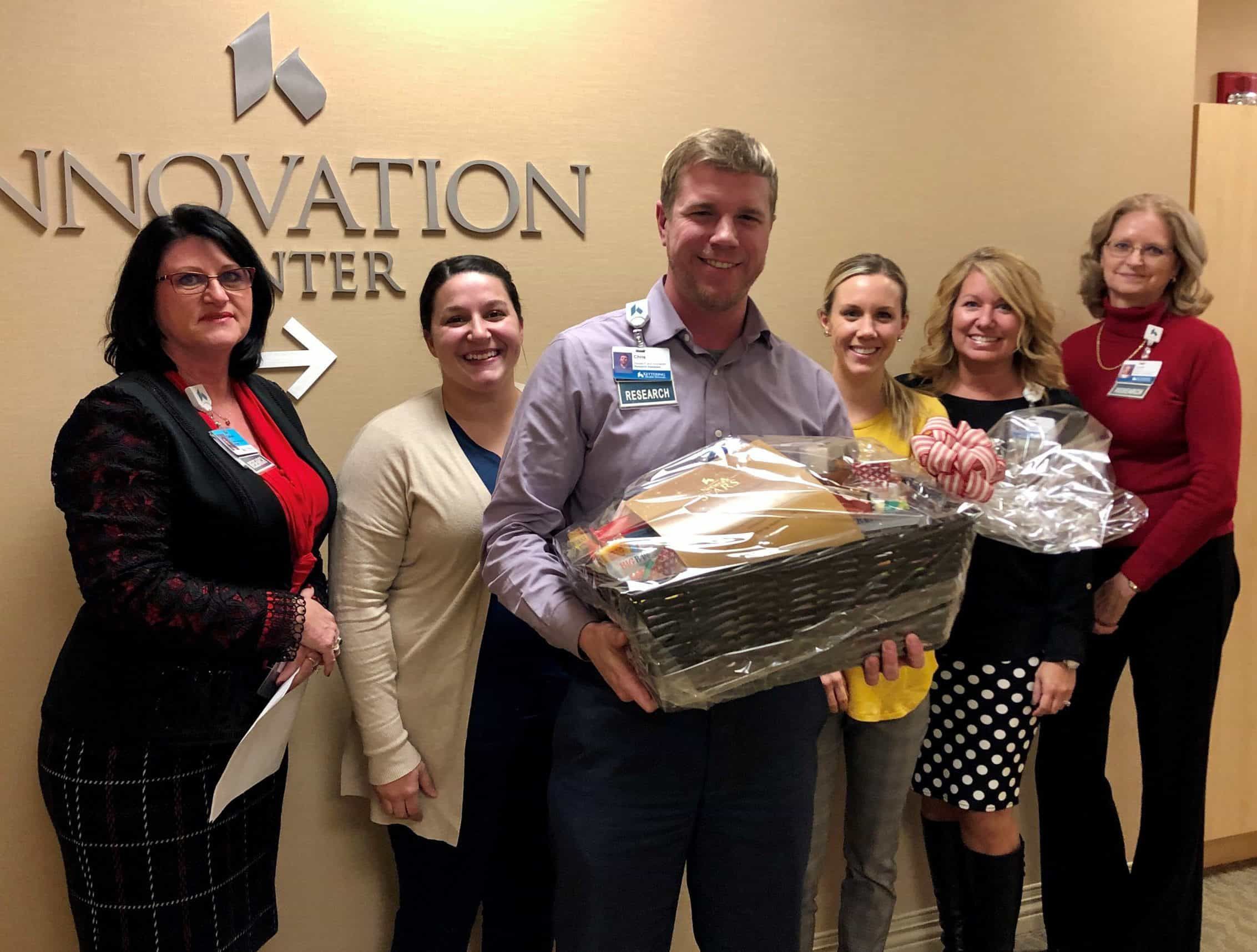 Group of healthcare employees presenting gift basket at Innovation Center
