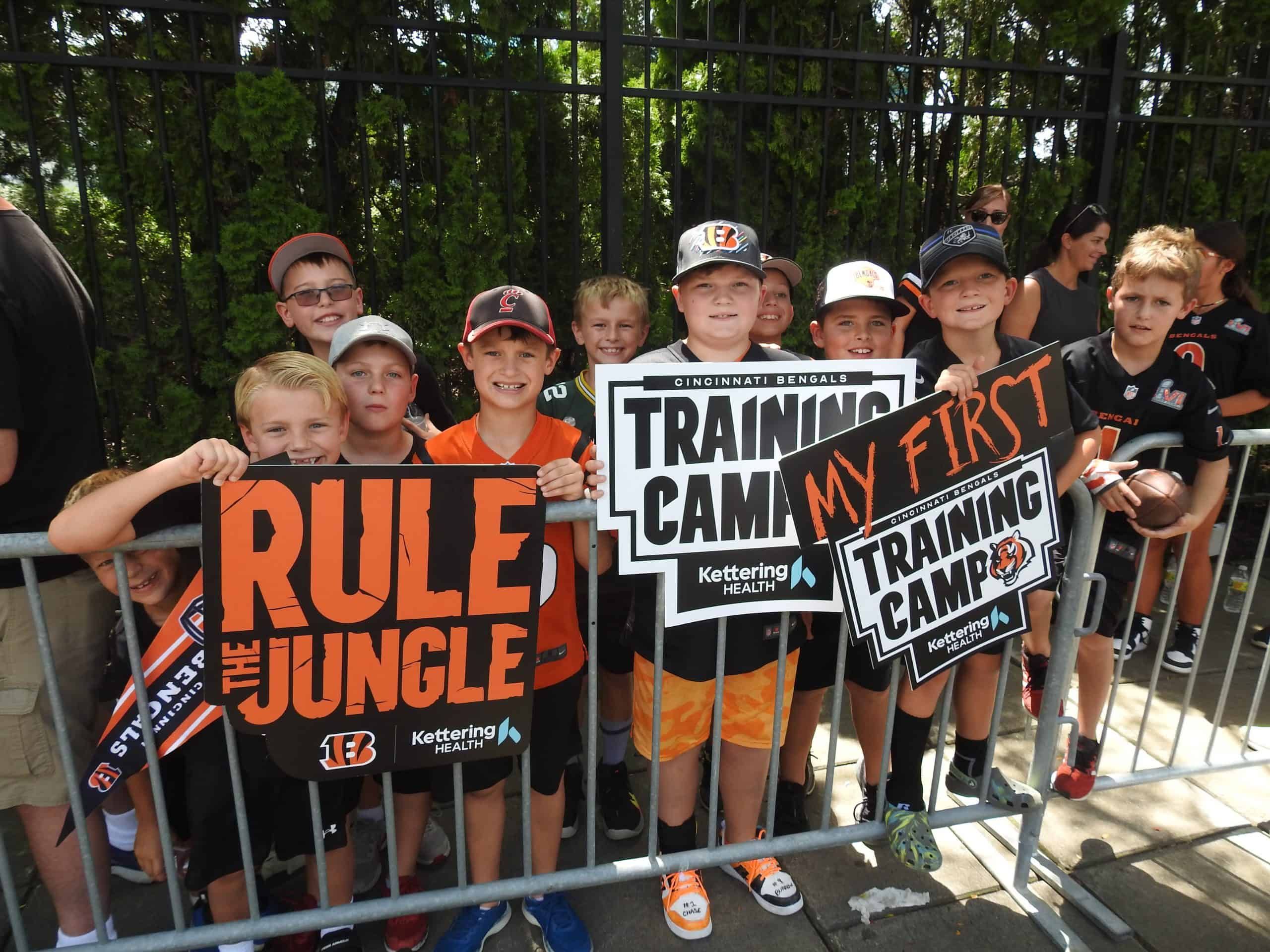 Young fans holding Cincinnati Bengals "Rule the Jungle" and "My First Training Camp" signs