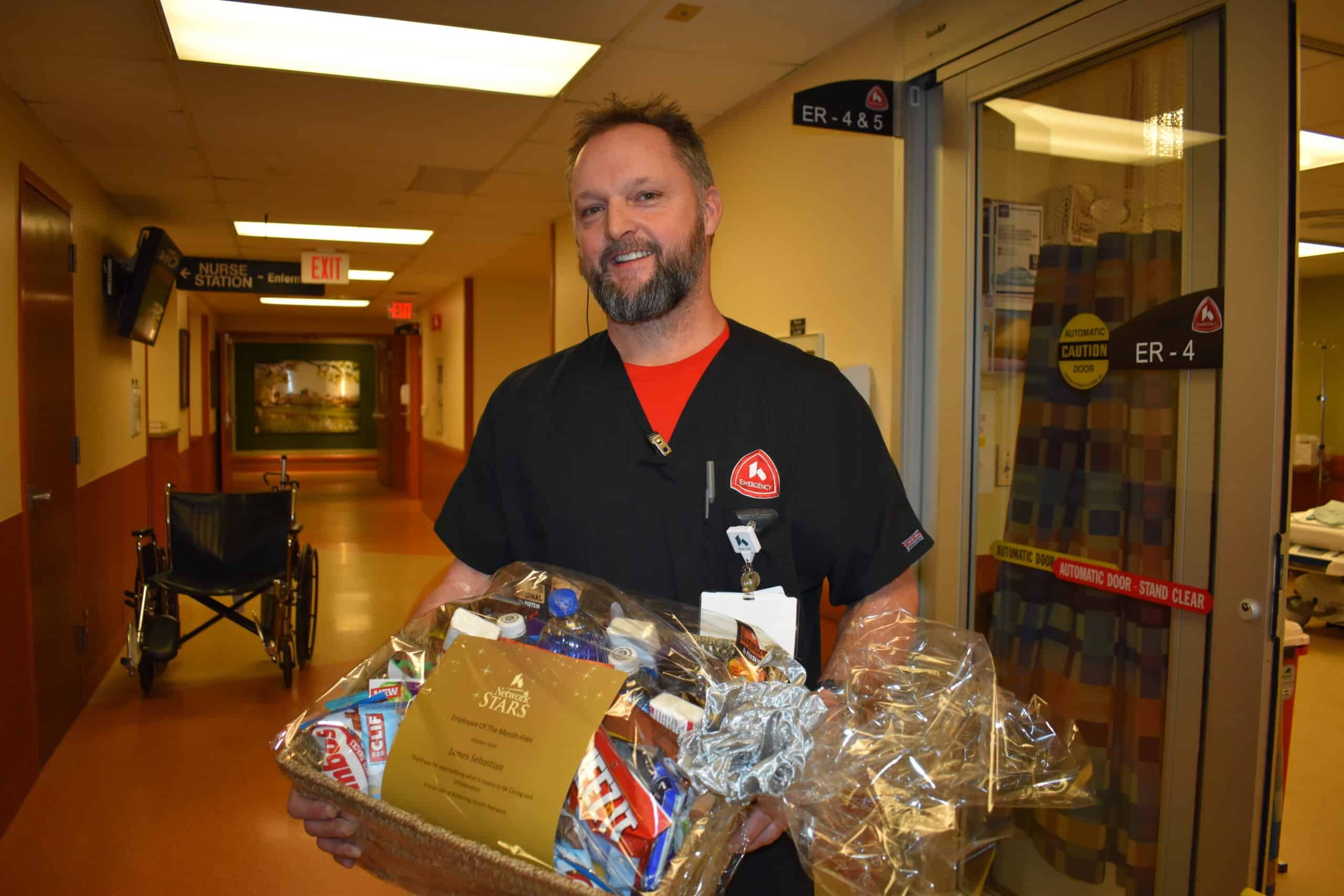 Healthcare worker holding gift baskets in hospital hallway near emergency room