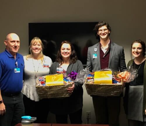 Five healthcare professionals holding gift baskets at Kettering Health recognition event