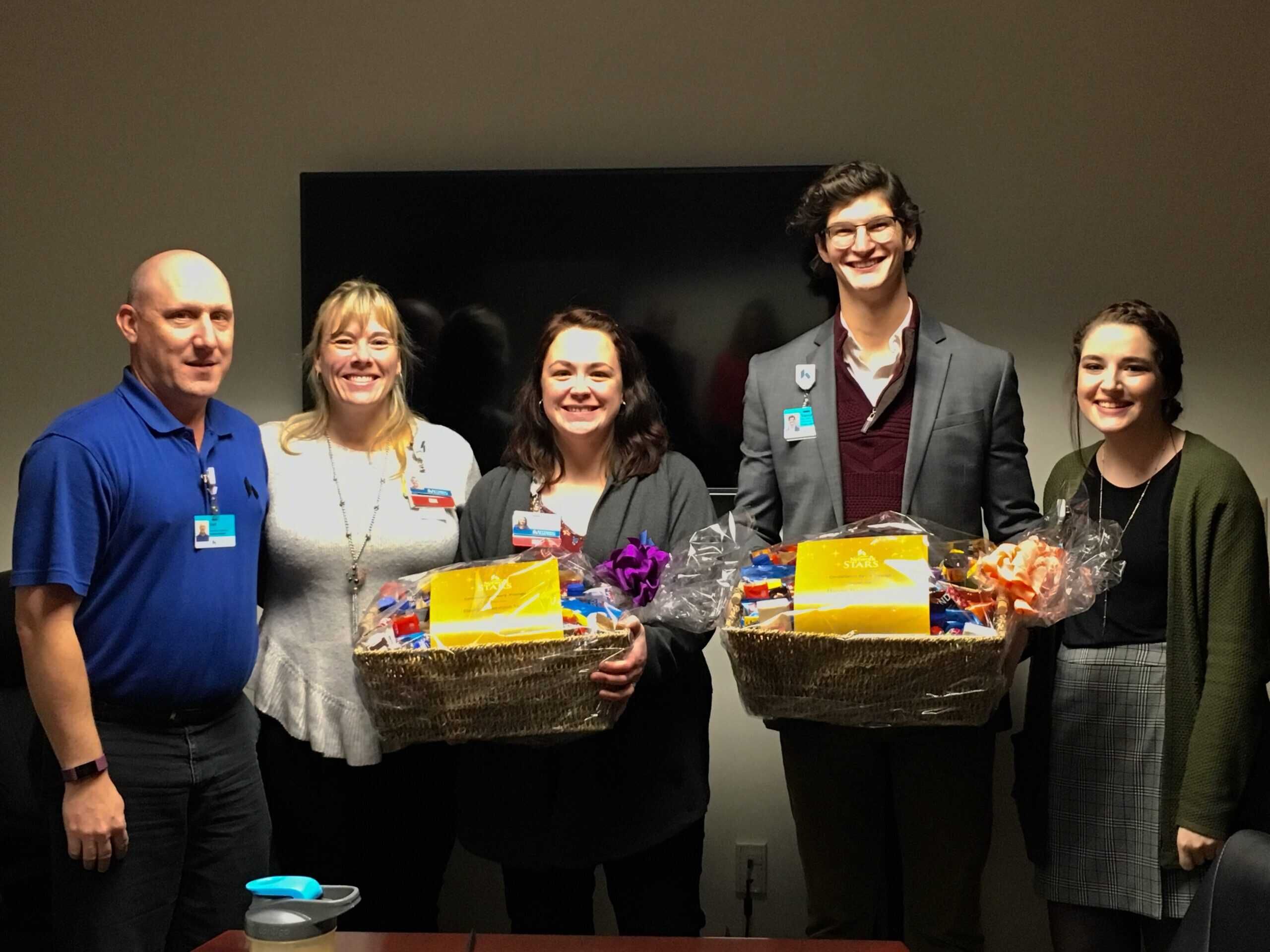 Five healthcare professionals holding gift baskets at Kettering Health recognition event