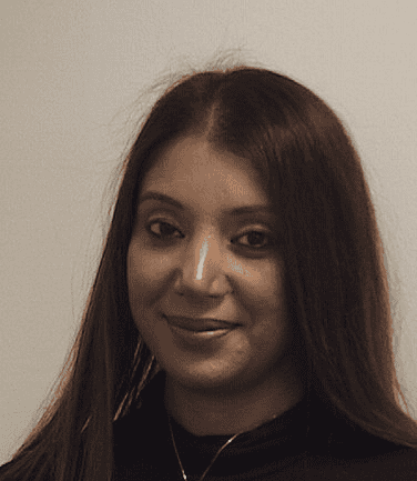 Young woman with long dark hair smiling at camera in professional headshot