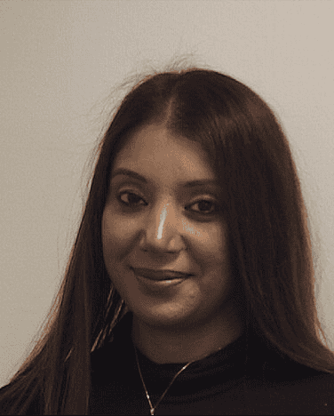 Young woman with long dark hair smiling at camera in professional headshot