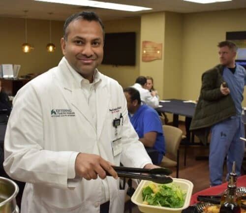 Doctor in white coat serving food at Kettering Health Doctors Day event