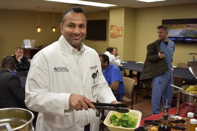 Doctor in white coat serving food at Kettering Health Doctors Day event