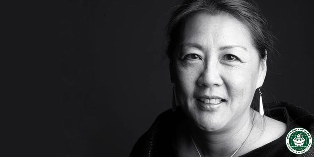 Professional headshot of Dr. Mau smiling against dark background in black and white