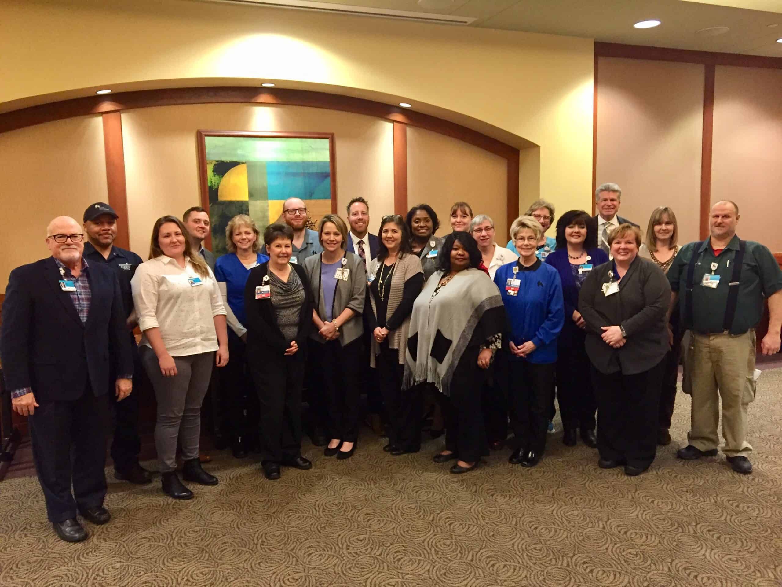 Group of healthcare employees posing together at Employee of the Month recognition luncheon.