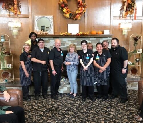Group of healthcare staff members posing together in decorated lobby area