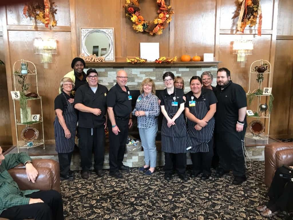 Group of healthcare staff members posing together in decorated lobby area